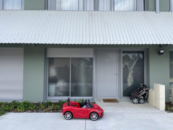 A ferrari parked in front of the garden apartment.